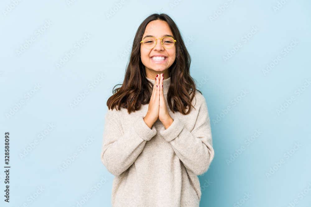 Young mixed race hispanic woman isolated holding hands in pray near mouth, feels confident. Young mixed race hispanic woman isolated holding hands in pray near mouth, feels confident.