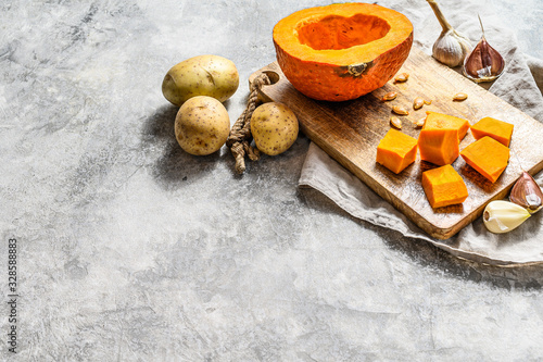 Chopped Pumpkin on rustic cutting board. Ingredients for pumpkin soup. Chopped Pumpkin on rustic cutting board. Tasty and healthy food. Vegan food. Space for text
