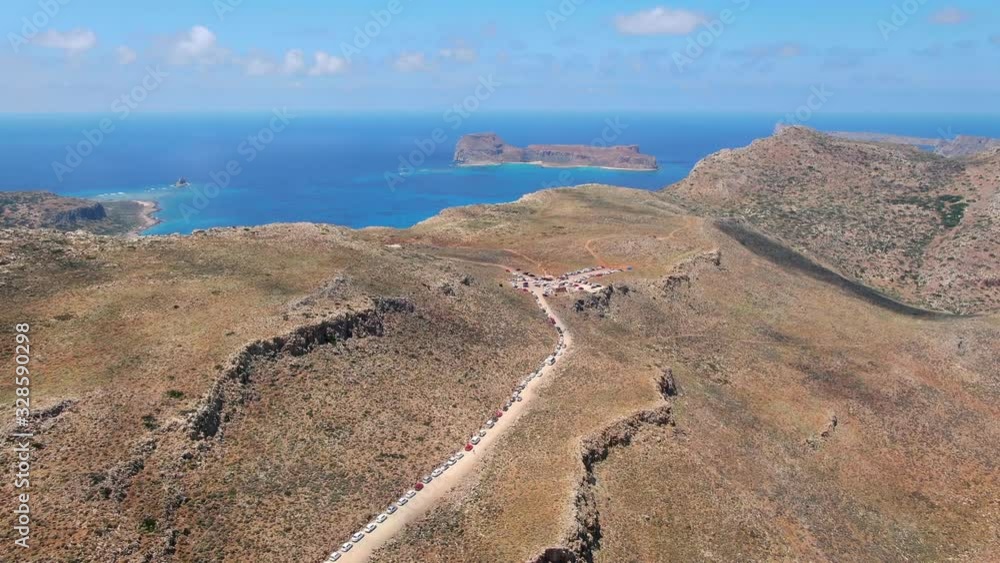 Dirt road on the peak of the mountain, in the background blue ocean that disappears on the horizon Dirt road on the peak of the mountain, in the background blue ocean that disappears on the horizon
