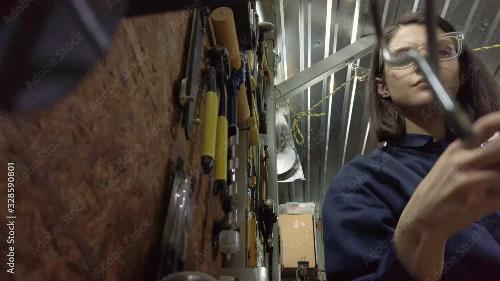 Attractive girl worker choosing tools for heavy work. Feminist women working with heavy tools, Gender equality. Attractive girl worker choosing tools for heavy work. Feminist women working with heavy tools, Gender equality.