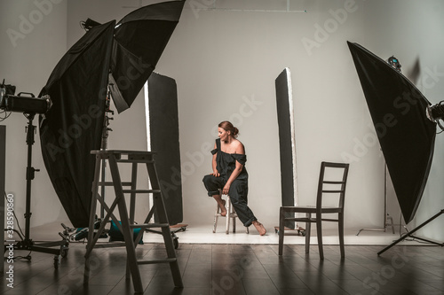 Beautiful and attractive model in black dress. Backstage shooting. Fashion, beauty, glamour concept. photo