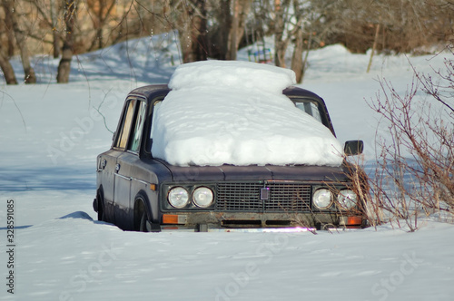 Snow covered car in the open field © John