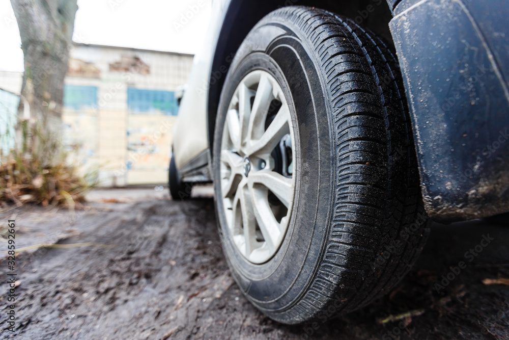 Wheel closeup in a countryside landscape with a muddy road