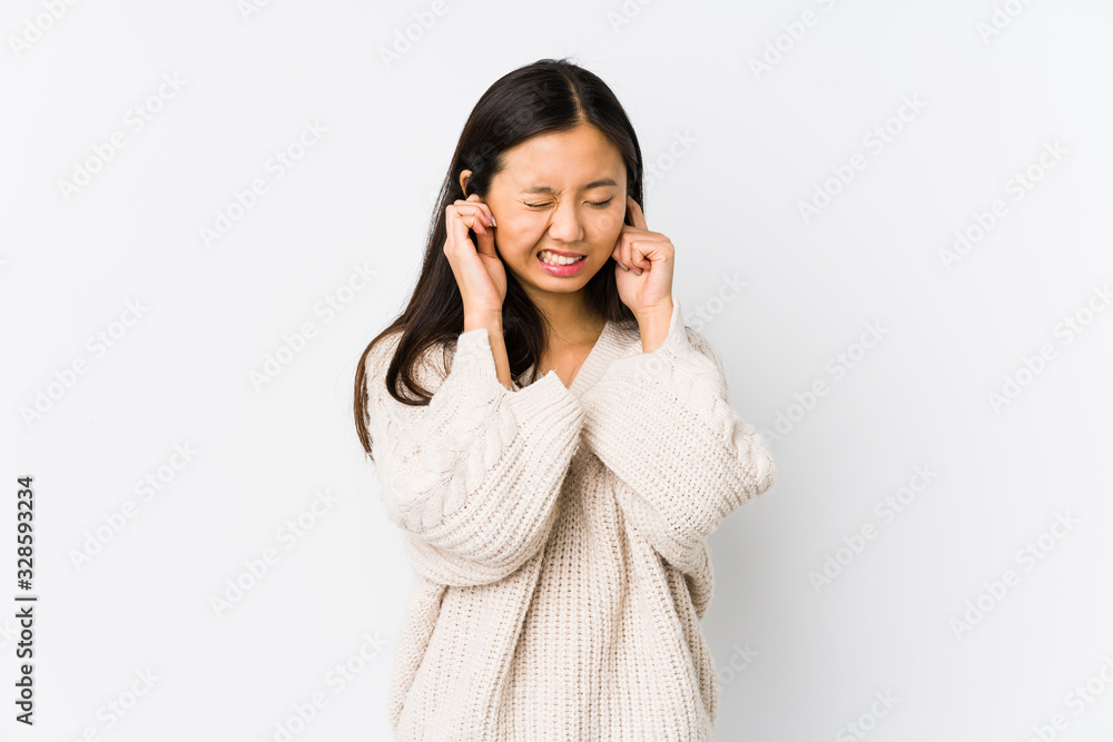 Young chinese woman isolated covering ears with hands. Young chinese woman isolated covering ears with hands.