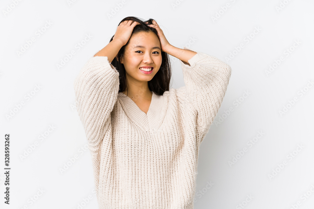 Young chinese woman isolated laughs joyfully keeping hands on head. Happiness concept. Young chinese woman isolated laughs joyfully keeping hands on head. Happiness concept.