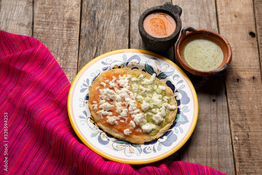 Mexican memela with green and red sauce on wooden background Mexican memela with green and red sauce on wooden background