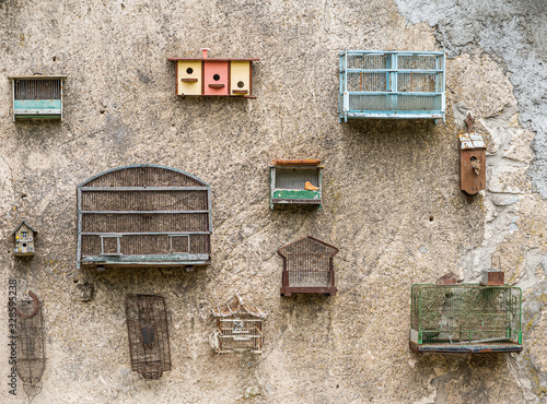 old birdcages on old cracked stone wall photo