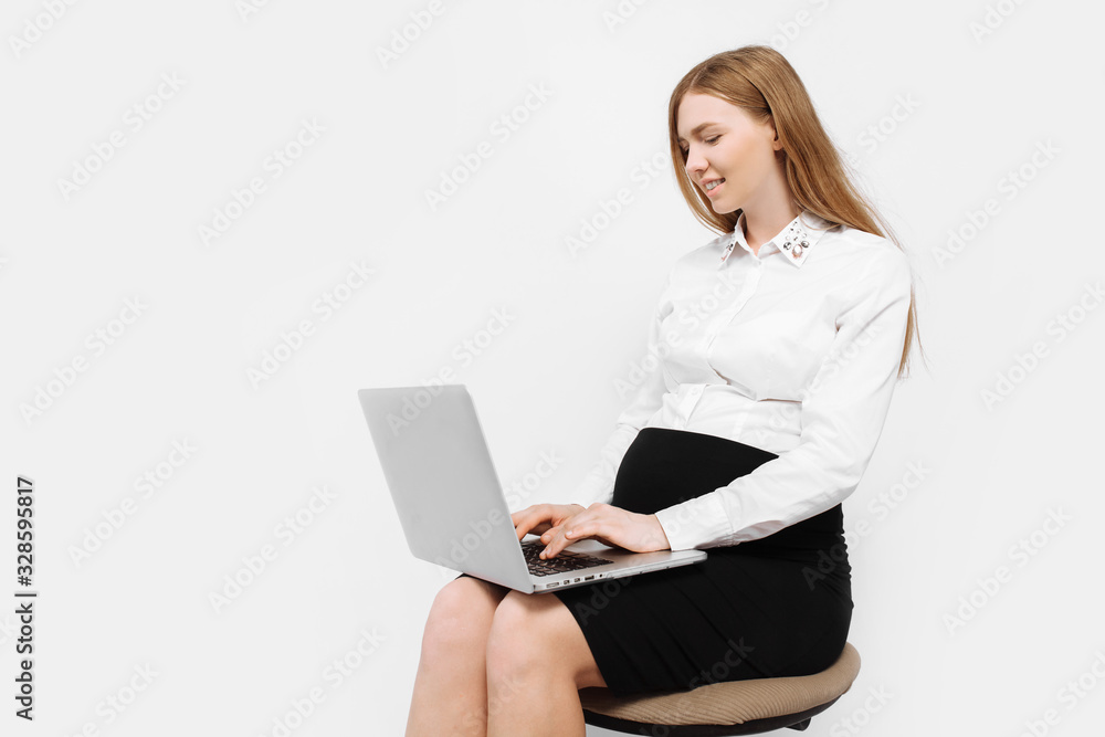 Image of young pregnant businesswoman in glasses, girl working with laptop, sitting on chair Image of young pregnant businesswoman in glasses, girl working with laptop, sitting on chair