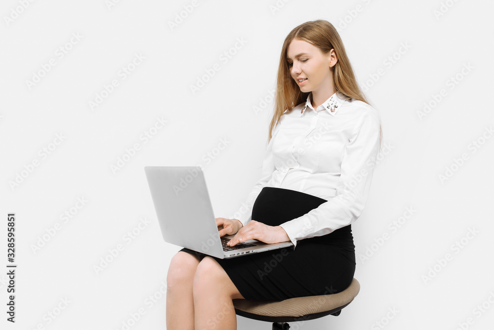 Image of young pregnant businesswoman in glasses, girl working with laptop, sitting on chair Image of young pregnant businesswoman in glasses, girl working with laptop, sitting on chair