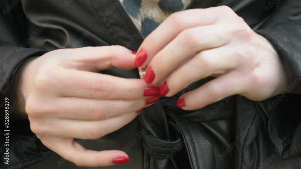 closeup hands. woman takes off a wedding ring while standing on the street closeup hands. woman takes off a wedding ring while standing on the street