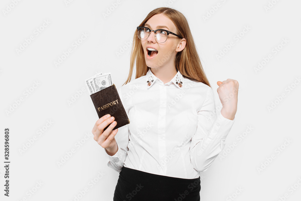 Image of a young pregnant businesswoman in glasses, a girl with a passport and money, preparing for a long-awaited vacation, depicts a gesture of victory Image of a young pregnant businesswoman in glasses, a girl with a passport and money, preparing for a long-awaited vacation, depicts a gesture of victory