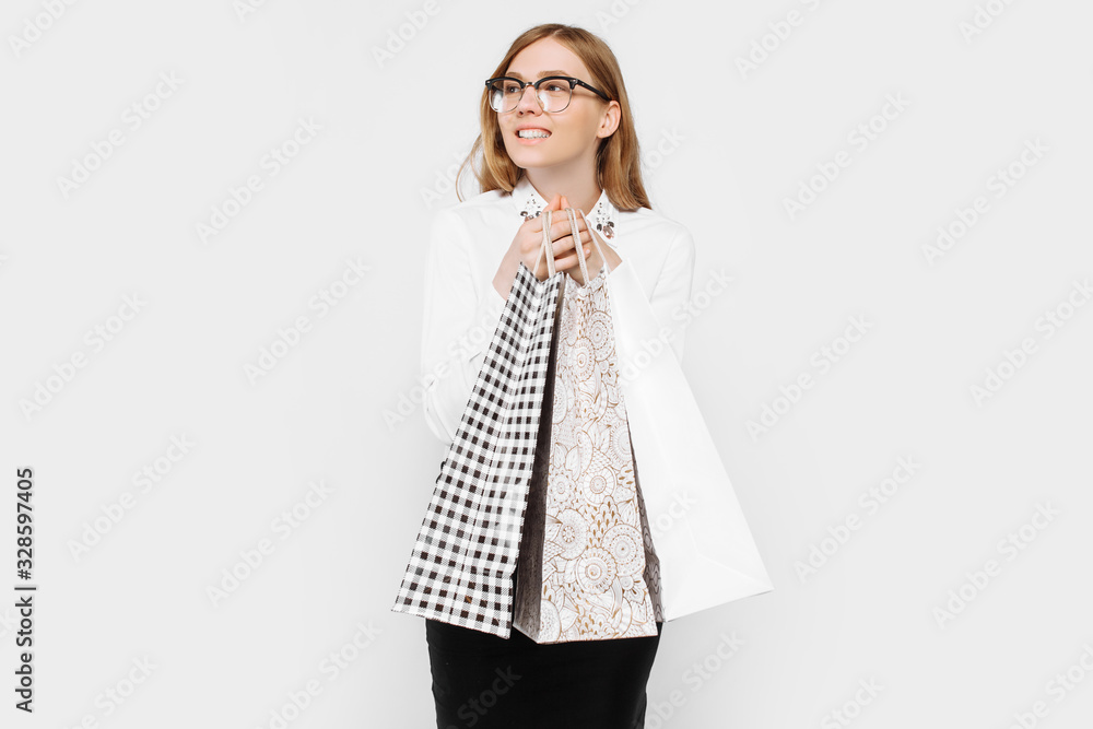 The image of a young pregnant businesswoman with glasses, happy girl holding shopping bags, shopping The image of a young pregnant businesswoman with glasses, happy girl holding shopping bags, shopping