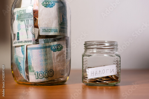 Russian rubles money and bottle with coins and inscription Taxes