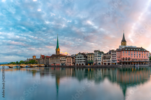 Panoramic view of famous Fraumunster and Church of St Peter and river Limmat at sunrise in Old Town of Zurich, the largest city in Switzerland