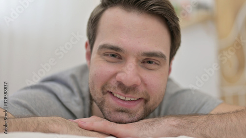 Close up of Young Man Smiling at Camera in Bed