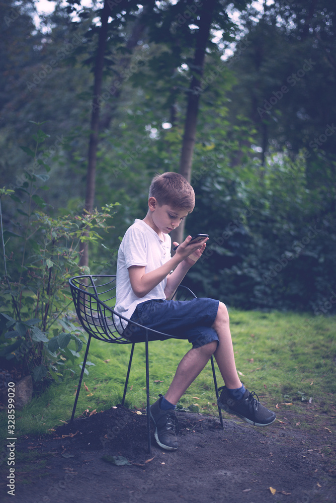 Teenager texting mobile phone messages row on nature background. Vertical frame