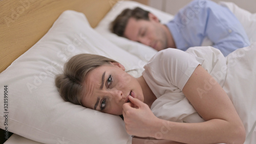 Upset Young Woman Thinking about Family Issues in Bed