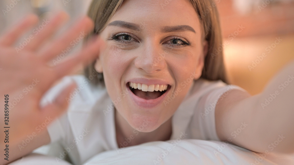 Close up of Cheerful Young Woman doing Video Chat in Bed Close up of Cheerful Young Woman doing Video Chat in Bed