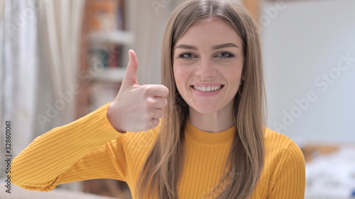 Portrait of Ambitious Young Woman showing Thumbs Up