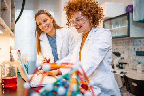 Two young female scientist doing experiments in lab. Scientific research team with clear solution in laboratory. Experienced female scientists is working in laboratory. Doing investigations