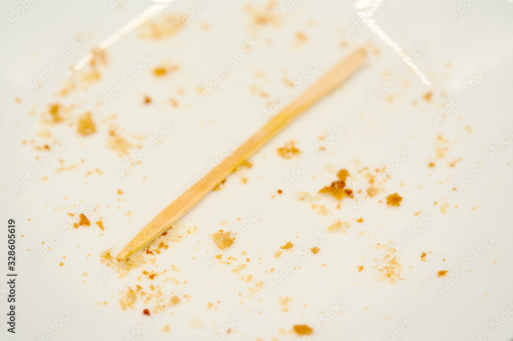 Crumbs and toothpick on empty plate Crumbs and toothpick on empty plate