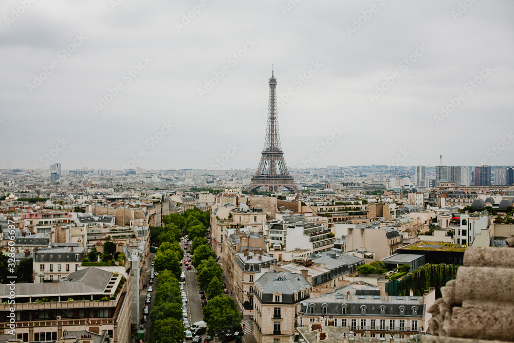 Top view on streets of Paris, buildings, roads with traffic and Eiffel tower 