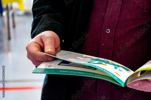 Draguignan, France - March 3, 2020: A man holding a handout on finding a job in the EU member countries during a forum on employment and entrepreneurship