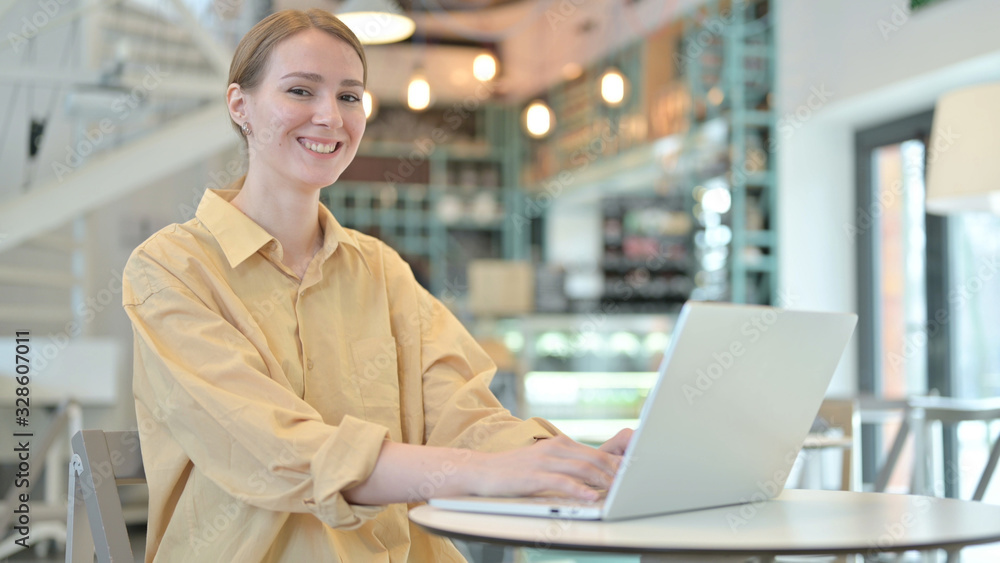 Young Woman Smiling at Camera in Cafe Young Woman Smiling at Camera in Cafe