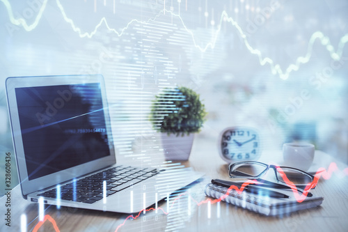 Forex graph hologram on table with computer background. Multi exposure. Concept of financial markets.