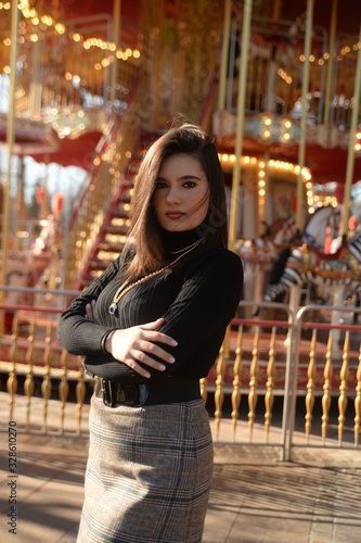 Portrait of a beautiful young woman near a carousel