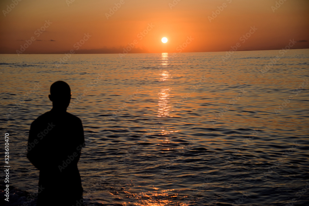 man observes beautiful sea sunset