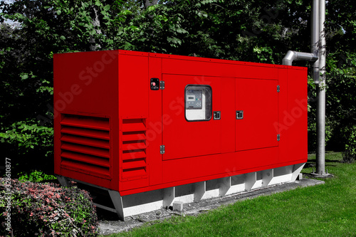 red diesel emergency generator for uninterruptible power supply, fuel installation in an iron casing with an electric switchboard power control.
