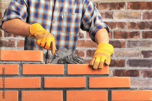 Bricklayer worker installing brick masonry