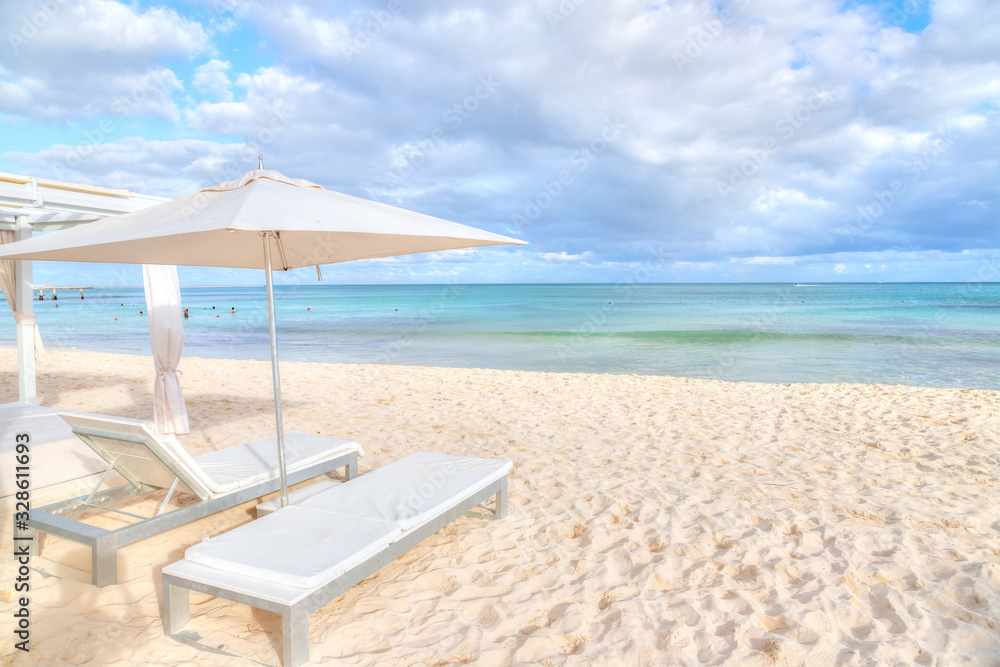 Lounge Chair Beds and Umbrella at White Sandy Beach in Caribbean