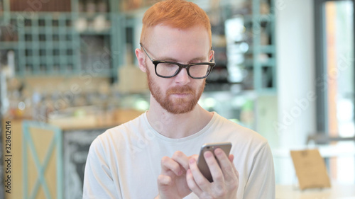 Portrait of Redhead Man Browsing Smartphone