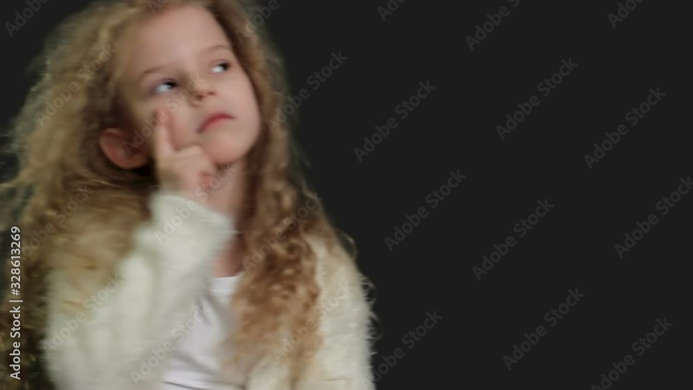 Little girl with blond curly hair, white shirt and white knitted jacket Little girl with blond curly hair, white shirt and white knitted jacket