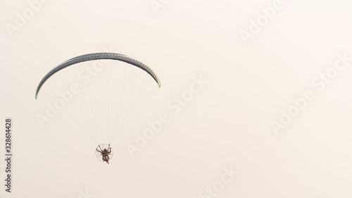 Pilots riding on a paramotor gliding in the sky