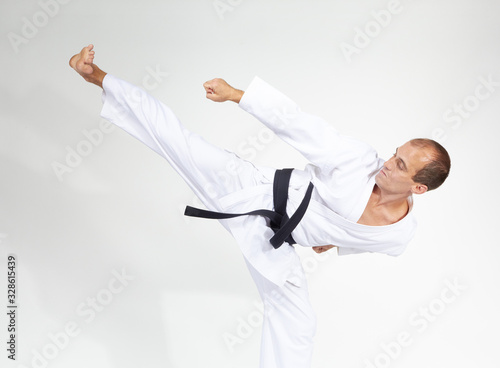 An athlete with a black belt beats kick Yoko geri