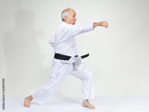 Man in karategi is beating kick gyaku-tsuki