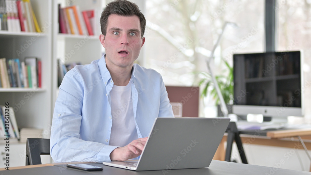 Fototapeta premium Shocked Young Man Working on Laptop