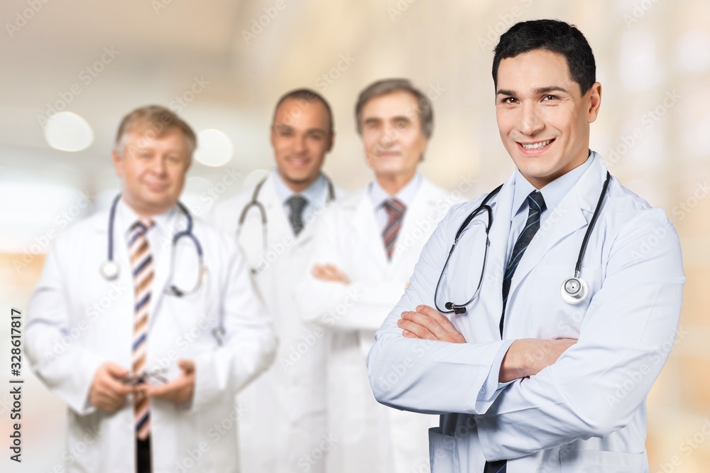 Young doctor portrait at blurred medical team background Young doctor portrait at blurred medical team background