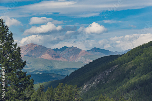 valley with pine forest and rocky peaks on horizon, mountain tourism, outdoor relaxation © Koirill