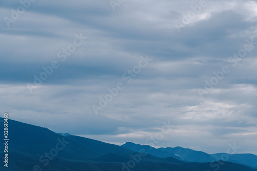 mountain valley under cloudy sky, rock ridge on horizon, hiking in  mountains, rest and meditation in nature © Koirill