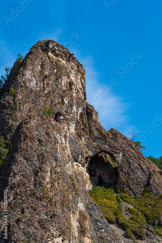 small cave or grotto in mountain cliff, mountaineering and caving in rocks