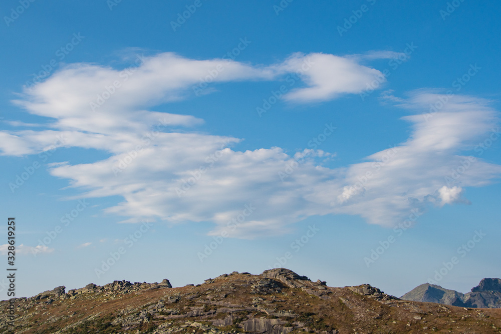 rocky ridge under blue sky in mountain valley, journey of climbers on sheer cliffs rocky ridge under blue sky in mountain valley, journey of climbers on sheer cliffs
