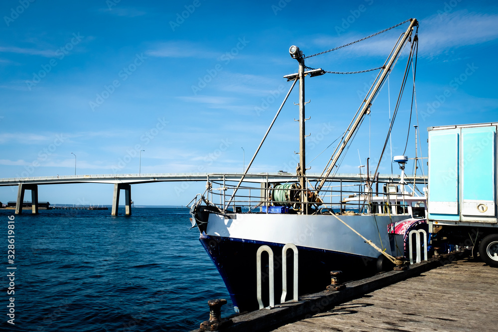 Fishing yachts parked at dock with a bridge connecting Phillip Island with San Remo area Fishing yachts parked at dock with a bridge connecting Phillip Island with San Remo area