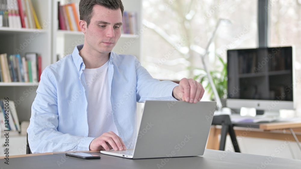Fototapeta premium Young Man Opening Laptop for Work