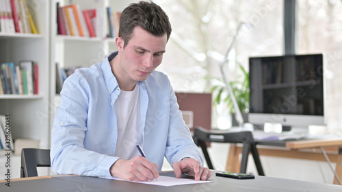Young Man Writing Documents, Doing Paperwork