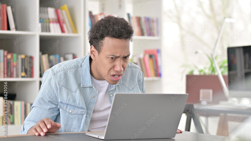 Young African American Man Disappointed by Loss on Laptop Young African American Man Disappointed by Loss on Laptop