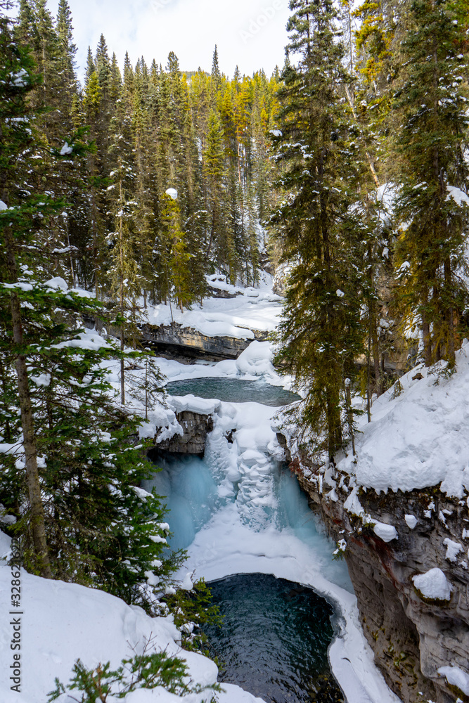 Frozen upper falls at Johnston Canyon Trail in winter, icy waterfalls landscape view. Banff National Park, Alberta, Canada
